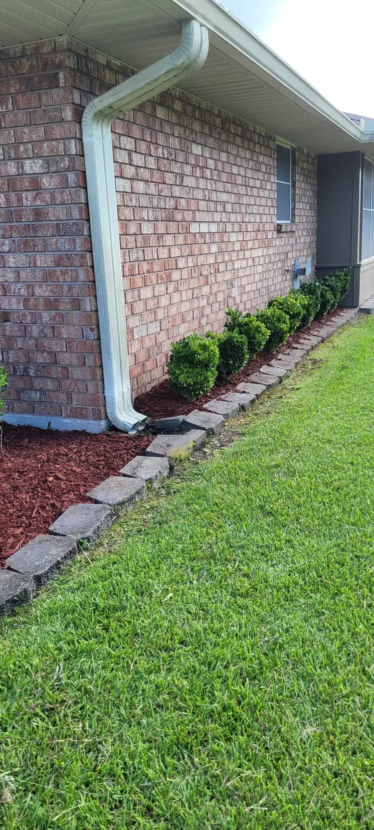 Fresh mulch bed and trimmed lawn at a Denham Springs home by Southern Buck Lawn