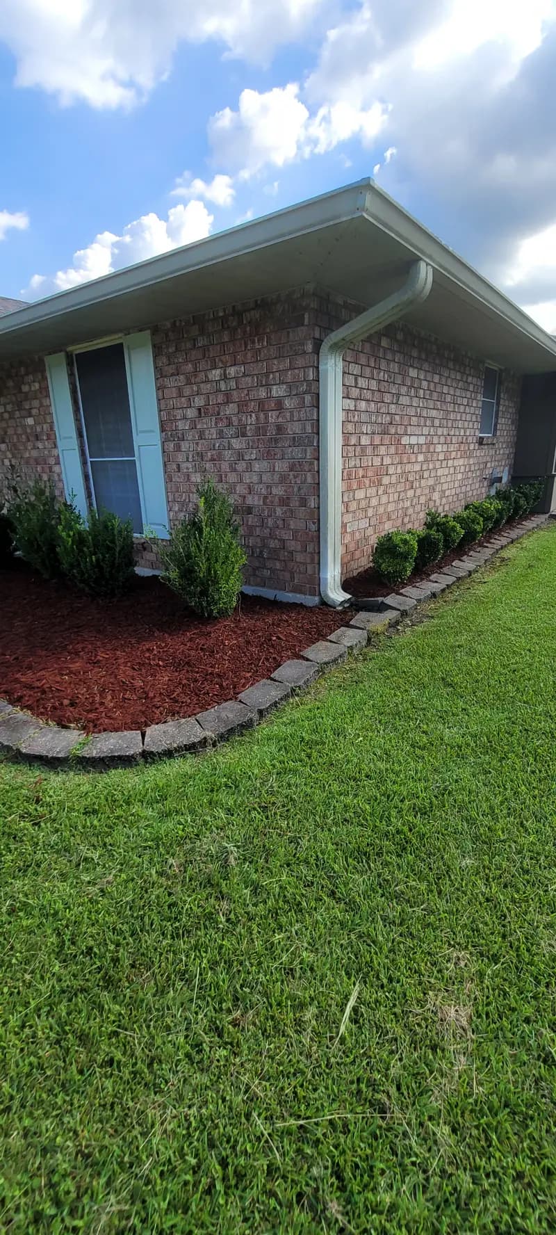 Healthy weed-free green lawn next to a mulched bed at a Denham Springs home