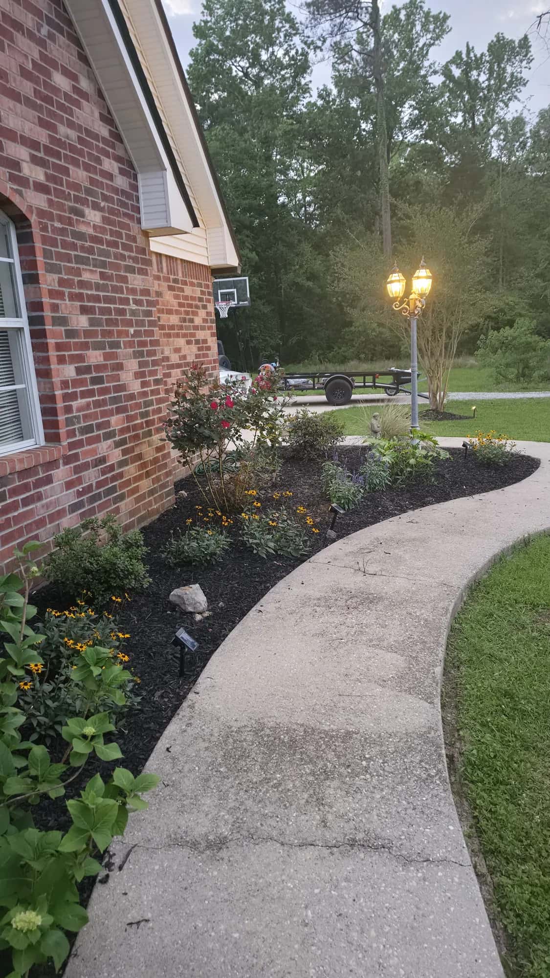 Brick house at dusk with path lights along the walk, Southern Buck Lawn lighting work.